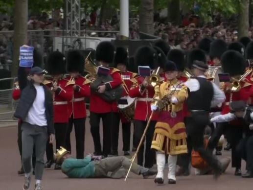 A crown-wearing protester hits the ground before his arrest. Picture: Supplied/Sky News UK