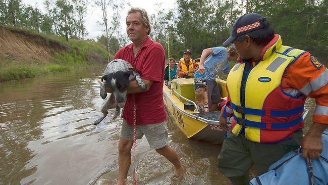 Goodnight Scrub local Scott Lucas and his dog Zac are evacuated by boat so they can spend Christmas in Bundaberg, Queensland. Picture: John Wilson