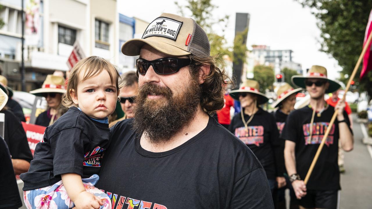 Zac Burton holds Posie Burton as he marches with the United Workers Union in the Labour Day 2022 Toowoomba march, Saturday, April 30, 2022. Picture: Kevin Farmer