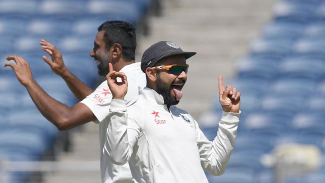 (FILES) This file photo taken on February 23, 2017 shows India's captain Virat Kohli (R) and teammate Ravichandran Ashwin celebrate after the dismissal of Australia's captain Steve Smith during the first day of the first cricket Test match between India and Australia at The Maharashtra Cricket Association Stadium in Pune. India clinched a hard-fought series against Australia 2-1 after winning the fourth and final Test in Dharamsala. ----IMAGE RESTRICTED TO EDITORIAL USE - STRICTLY NO COMMERCIAL USE----- / GETTYOUT---- / AFP PHOTO / INDRANIL MUKHERJEE / ----IMAGE RESTRICTED TO EDITORIAL USE - STRICTLY NO COMMERCIAL USE----- / GETTYOUT