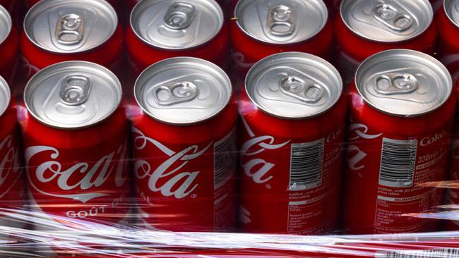 This photograph shows Coca-Cola soft drink cans wrapped in plastic in Paris on September 16, 2024. (Photo by JOEL SAGET / AFP)