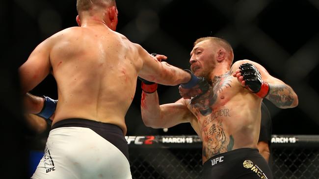 Nate Diaz (L) punches Conor McGregor during UFC 196.