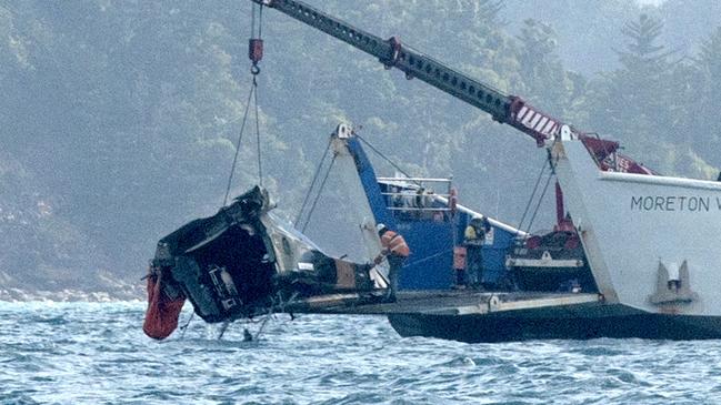 A barge anchored at the site where a MRH 90 military helicopter crashed, lifts out the tail section. in the Whitsundays while carrying four AustraliansPicture:Michaela Harlow