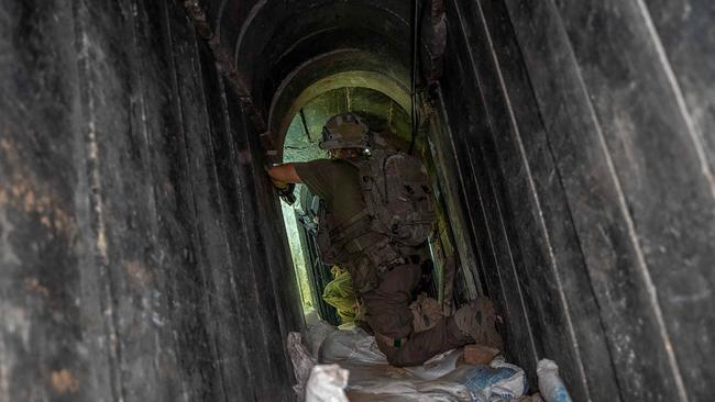 An Israeli soldier pictured in May, kneeling inside the section of a tunnel during operations the army said were to rescue hostages and destroy underground tunnels in the Gaza Strip. Picture: Israeli Army / AFP