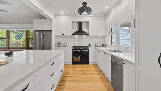 The house’s kitchen contains stone benchtops, a dishwasher, induction cooktop and Belling dual oven.