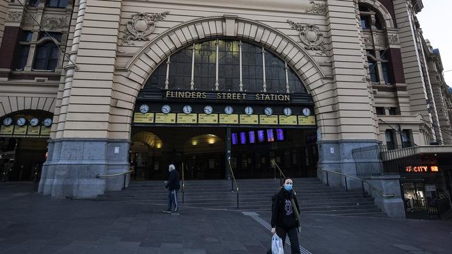 People walk past an empty Flinders Street Station on Sunday.