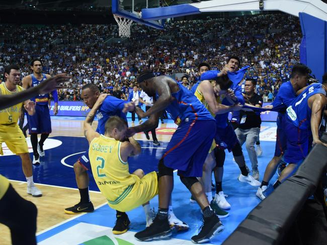 Players from benches run to their teammates who figured in a brawl during the match between Australia and the Philippines