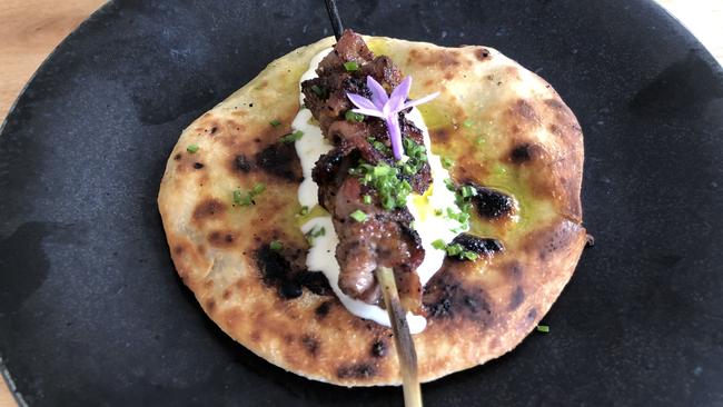 Lamb neck skewers, yoghurt on flatbread.