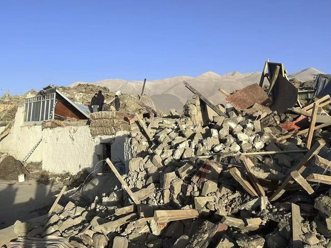 People stand in the rubble in Tonglai Village, Changsuo Township of Dingri in Xigaze. Picture: Xinhua via AP