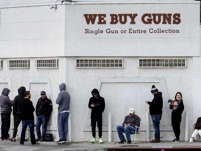 People wait in a line to enter a gun store in Culver City, Calif., Sunday, March 15, 2020. Coronavirus concerns have led to consumer panic buying of grocery staples and now gun stores are seeing a run on weapons and ammunition as panic intensifies. (AP Photo/Ringo H.W. Chiu)