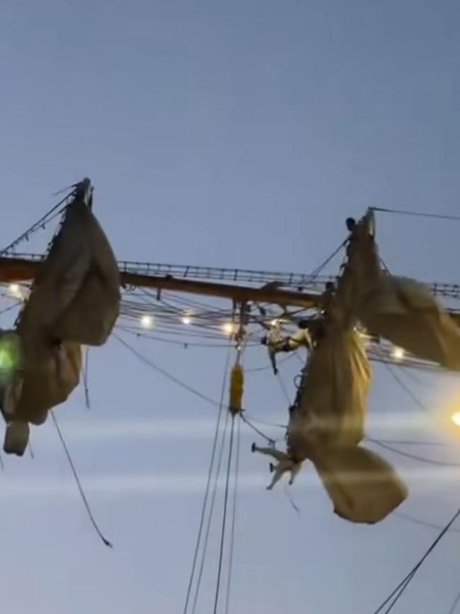 Pictures from social media show crew members dangling from ropes after the Mexican Navy tall ship crashed in to the Brooklyn Bridge. Picture: Instagram