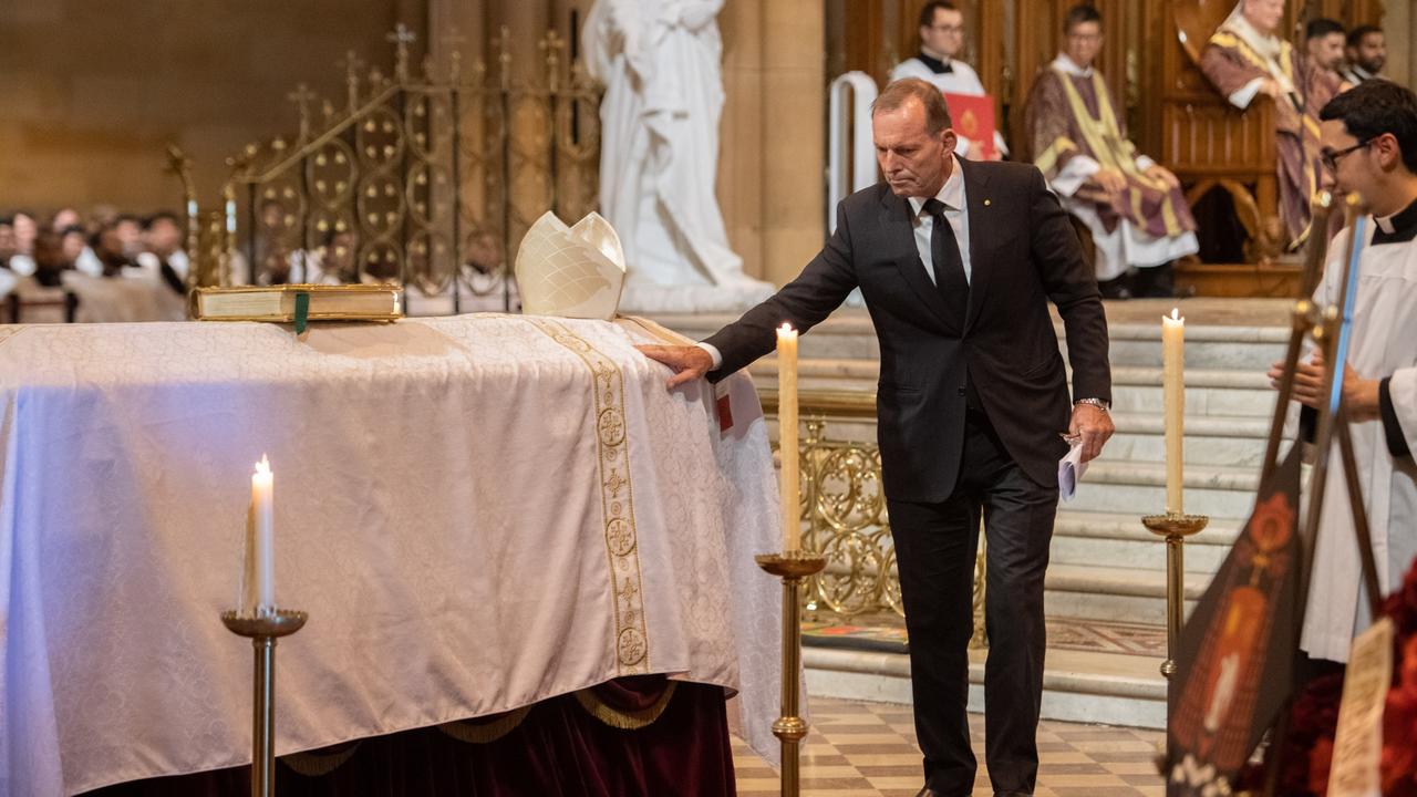 Former Prime Minister Tony Abbott touches the coffin of George Pell at the Solemn Pontifical Mass at St Mary's Cathedral in Sydney. Picture: Giovanni Portelli/The Catholic Weekly
