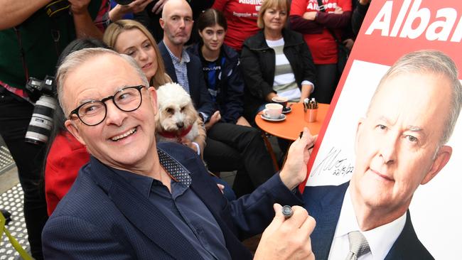 Anthony Albanese signs a poster for a young boy while enjoying a coffee the morning after his ‘baby steps of change’ campaign brought victory for Labor. Picture: Getty Images