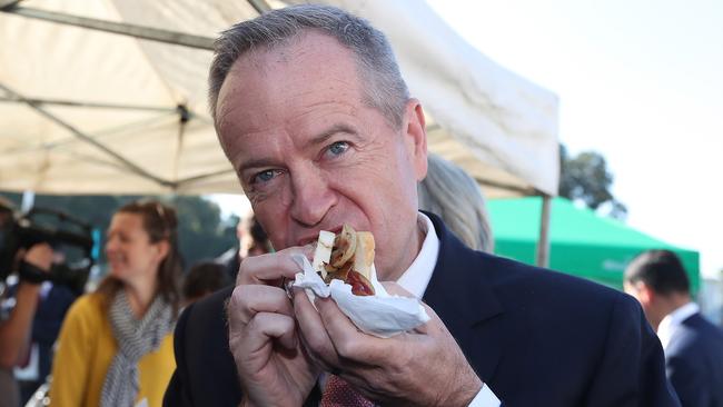 Bill Shorten eating a sausage sandwich after voting. Picture: Kym Smith