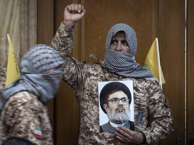 An Islamic Revolutionary Guard Corps (IRGC) military personnel, wearing a Palestinian scarf and a uniform symbolizing Hamas warriors, shouts anti-U.S. and anti-Israeli slogans while holding a portrait of Lebanon's Hezbollah Secretary General, Hashem Safieddine, who is killed in an Israeli airstrike, during a ceremony commemorating the killed Hamas leader, Yahya Sinwar, at a mosque in downtown Tehran, Iran, on October 24, 2024. (Photo by Morteza Nikoubazl/NurPhoto)NO USE FRANCE