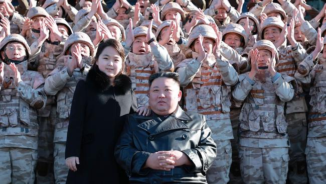 North Korea's leader Kim Jong Un and his daughter posing with soldiers who contributed to the test-firing of the new intercontinental ballistic missile (ICBM), at an unknown location in North Korea. Picture: KCNA via KNS/AFP.