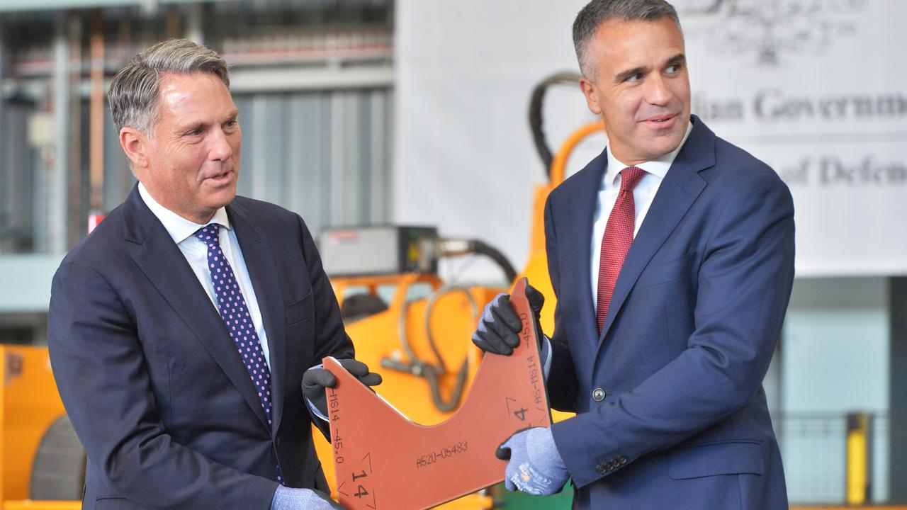 Defence Minister Richard Marles and SA Premier Peter Malinauskas hold the first cut piece of steel to be used on the first Hunter class frigate to be constructed at the Osborne Naval Shipyard in Adelaide. Picture: NewsWire / Brenton Edwards