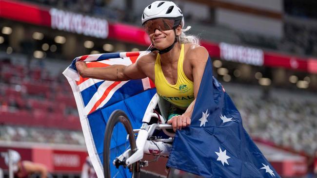 Madison De Rozario draped in the Australian flag after her epic race. Picture: AFP