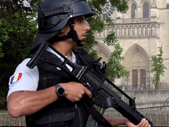 A French police officer holds a weapon as he stands near the entrance of Notre-Dame cathedral in Paris on June 6, 2017.  Anti-terrorist prosecutors have opened a probe after police shot and injured a man who had tried to attack an officer with a hammer outside Notre Dame cathedral. The officer was slightly injured in the attack outside the world-famous landmark in central Paris. One of his colleagues responded by shooting him, wounding the attacker, whose motives were not immediately known, according to a police source.   / AFP PHOTO / bertrand GUAY