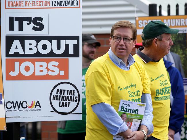 Nationals leader Troy Grant cuts a lonely figure amid a cavalcade of noisy anti-Nationals volunteers at the Bletchington Public School booth. Picture: Jonathan Ng