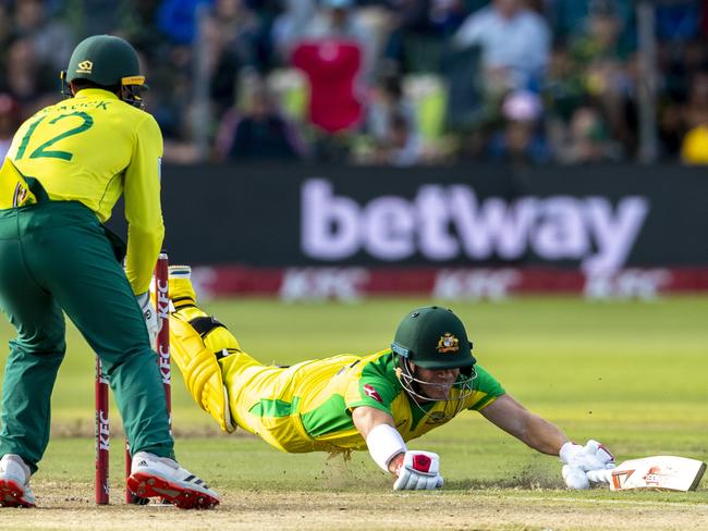 David Warner dives to survive a run out attempt by South Africa's captain Quinton de Kock. Picture: AP Photo/Themba Hadebe