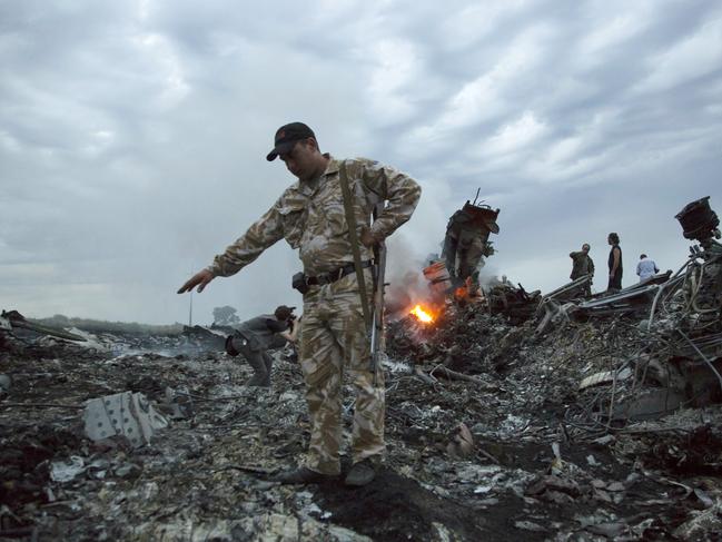 Military walk among the debris at the crash site of MH17 passenger plane near the village of Grabovo, Ukraine, that left 298 people killed in 2014. Picture: AP