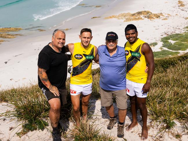 Richmond players Rhyan Mansell and Maurice Rioli model the club's Dreamtime guernseys created by Mansell and father Brett, left and grandfather Clyde, third from left. Picture: Lucy Edwards/Richmond Media