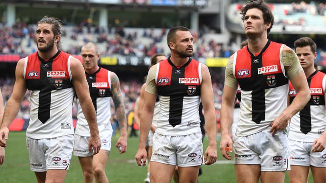 St Kilda players walk off the MCG after losing to Melbourne.