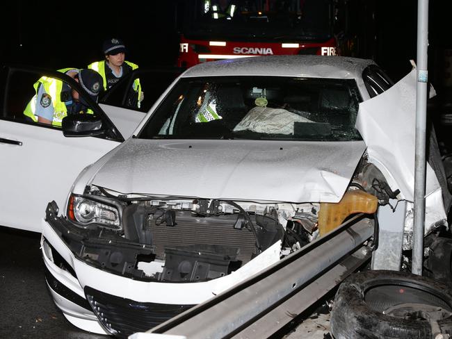 Three passengers are lucky to have survived after the driver of a Chrysler 300C lost control on a bend in Bondi Road, Bondi and sliced his car open with a steel safety barrier. Picture: Bill Hearne