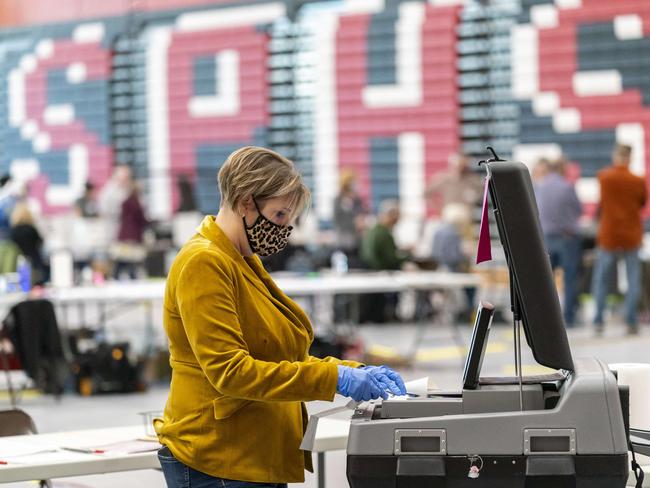 Poll worker Rebecca Brandt feeds a voting tabulation machine with absentee ballots in the gym at Sun Prairie High School in Sun Prairie, Wisconsin. Picture: Andy Manis/Getty Images/AFP