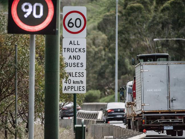 A truck is seen passing a “60 All Trucks and Buses” sign on the South Eastern Freeway. Picture: AAP Image/Morgan Sette