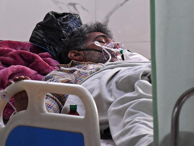 In this picture taken on May 5, 2021, a Covid-19 coronavirus patient breathes with the help of an oxygen mask inside the Intensive Care Unit (ICU) of the Teerthanker Mahaveer University (TMU) hospital in Moradabad. - People in India's most populous state Uttar Pradesh are fighting not just a raging pandemic but also a prickly Hindu nationalist local government that many say is in denial. (Photo by Prakash SINGH / AFP) / To go with 'VIRUS-HEALTH-INDIA-UP', Focus by Jalees ANDRABI