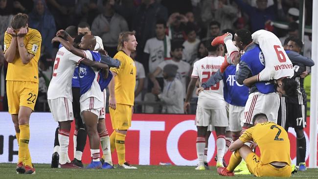 UAE players celebrate as the Socceroos contemplate their early departure.