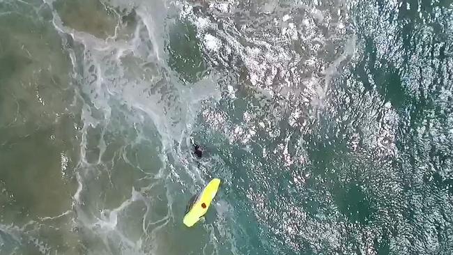 The Westpac Little Ripper drone drops an inflatable rescue device to the surfers