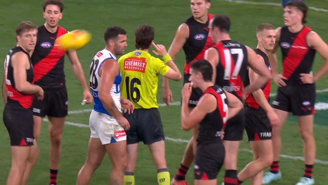 The umpire puts a finger to his ear and changes his decision. Photo: Fox Footy.