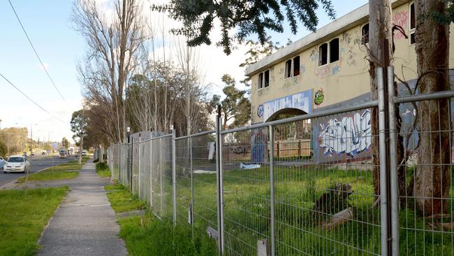 The abandoned buildings on Canterbury Rd, Ringwood are covered in graffiti, with every window smashed, doors missing, ceilings hanging down, and rubbish strewn around the site