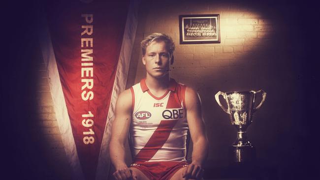 Isaac Heeney sports the Swans commemorative jumper with a replica Premiership flag and cup from 1918. Picture: Phil Hillyard