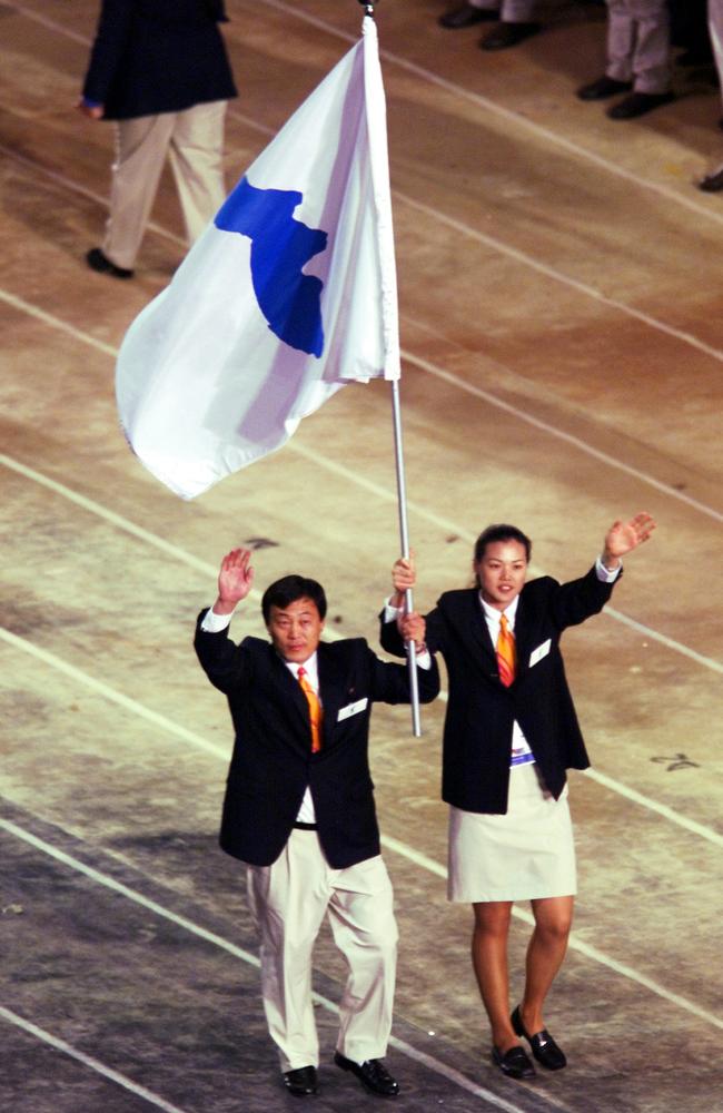 North Korean judo coach Pak Jung Chul (left) and Chung Eun-sun, a South Korean basketball player, carry a flag representing a united Korea into the Olympic Stadium at the Opening Ceremony of the Sydney Olympics on September 15, 2000.