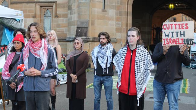 Pro-Palestine protesters and student representative council members Harrison Brennan (Red woollen jacket and keffiyeh) and Deaglan Godwin (left, foreground) hold a press conference at the University of Sydney encampment in May. Picture: James Dowling