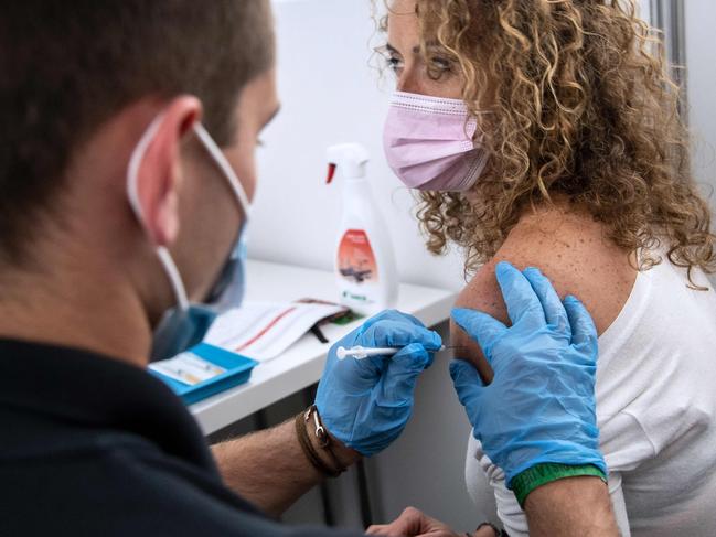 A French red cross member administers a dose of the Pfizer vaccine to a woman in Paris. Picture: AFP