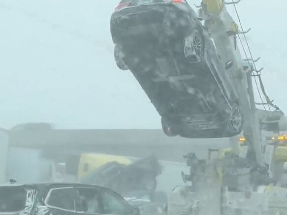 A car is lifted by a crane after the huge pileup.