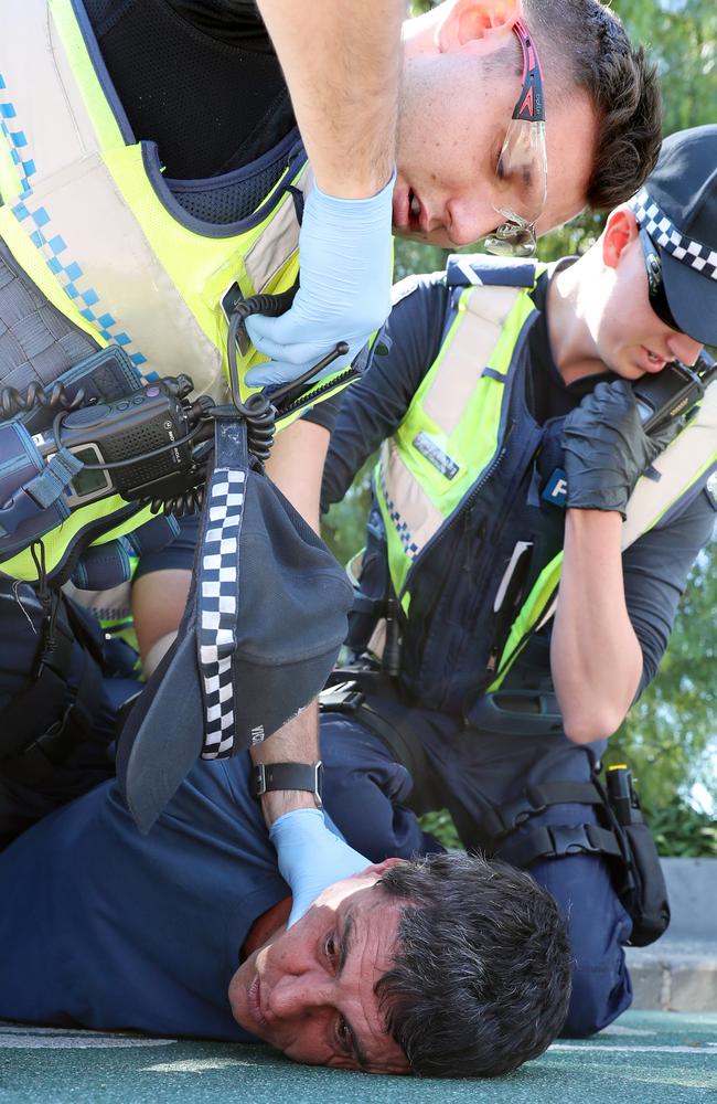 Officers surround the man as he becomes increasingly aggressive. Picture: Alex Coppel.