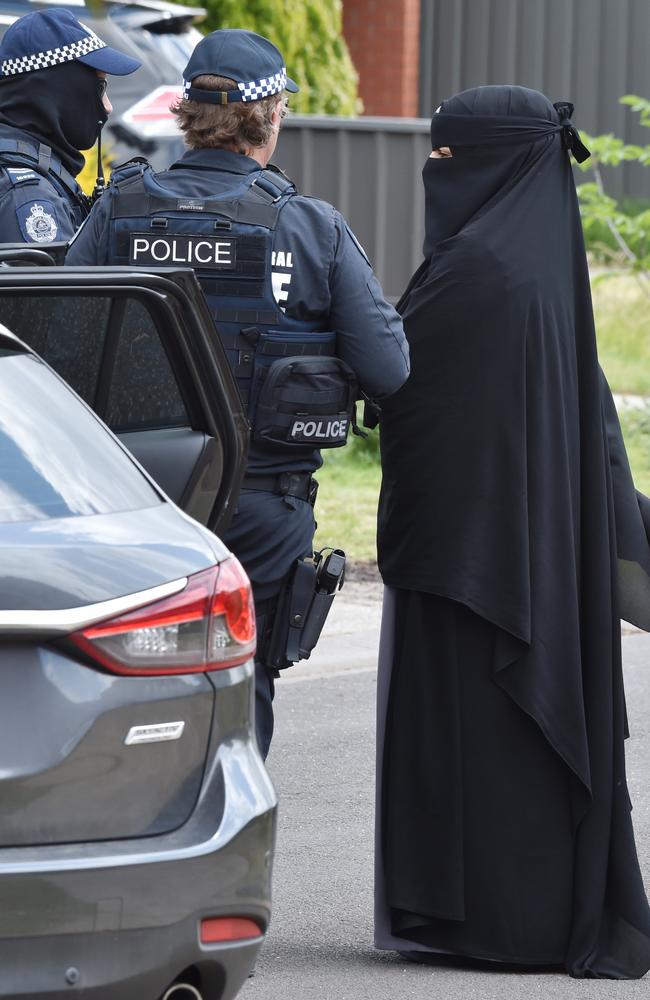 Police speak with a woman at Meadow Heights. Picture: Jay Town