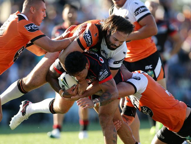 Warriors Issac Luke tackled by Tigers Aaron Woods.