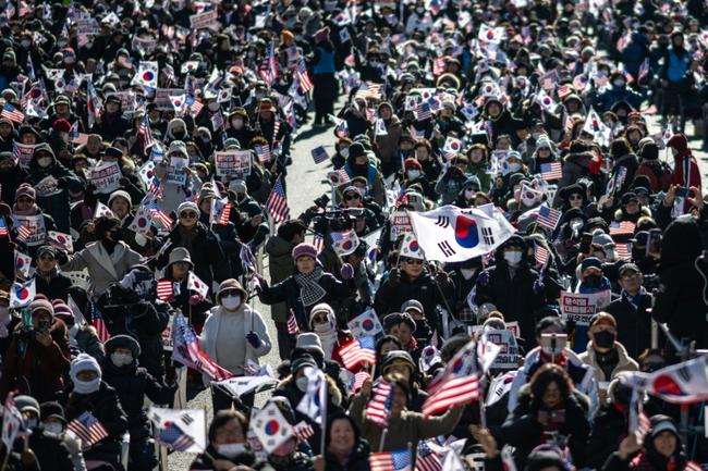 People wave US and South Korean flags during a rally in support of impeached South Korea president Yoon Suk Yeol