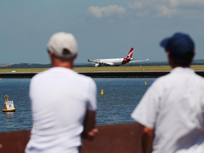 Plane spotters look on as an Airbus A330-300 aircraft operated by Qantas Airways Ltd. taxis at Sydney Airport in Sydney, Australia, on Monday, Feb. 22, 2016. Qantas Airways is scheduled to announce half-year earnings on Feb. 23. Photographer: Brendon Thorne/Bloomberg