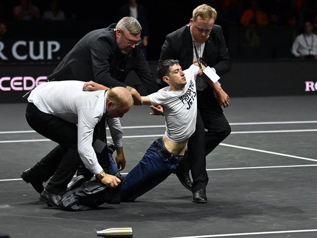 A protester is removed after setting himself on fire at the 2022 Laver Cup in London. Picture: AFP