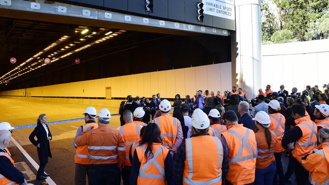 Construction workers and guests watch on as NSW Premier Gladys Berejiklian speaks to the media during a press conference in front of the new M4 WestConnex tunnel at Homebush. Picture: Bianca De Marchi