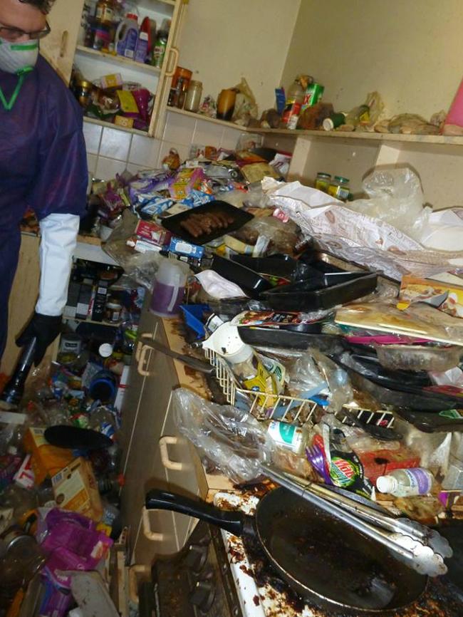 An RSPCA worker inspects the filthy kitchen.