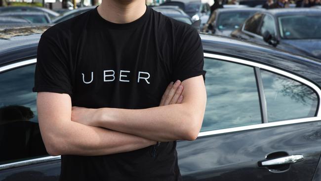 A protester wears a shirt displaying the logo of smartphone ride service Uber.